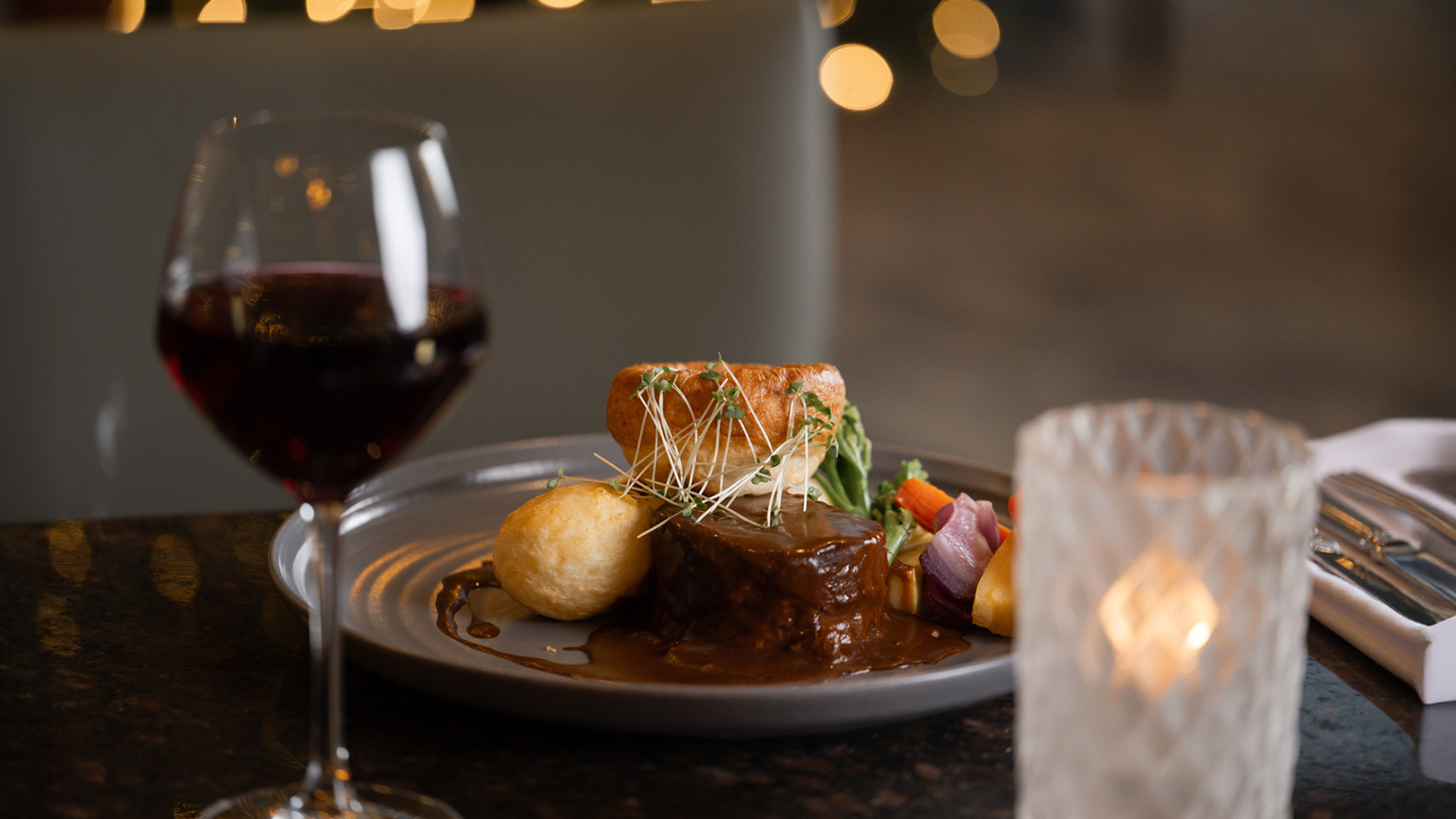 Elegant hotel dining with gourmet meal, wine, and romantic candlelight, offering a luxurious culinary experience.
